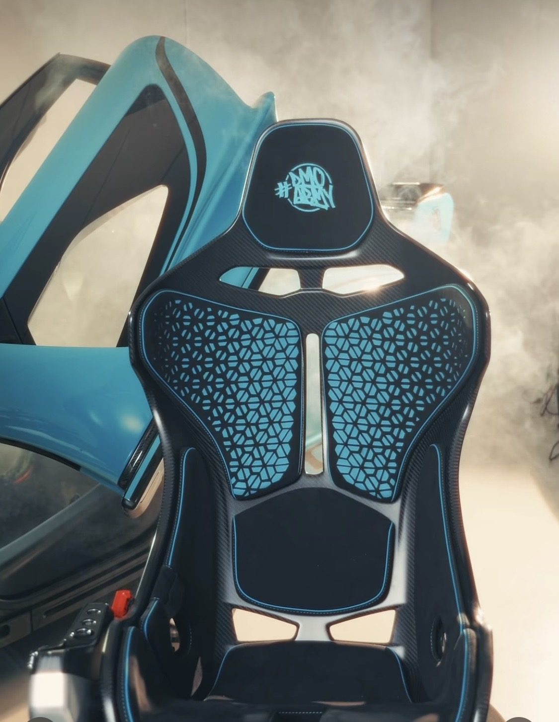 Racing seat with laser-cut pattern and headrest emblem